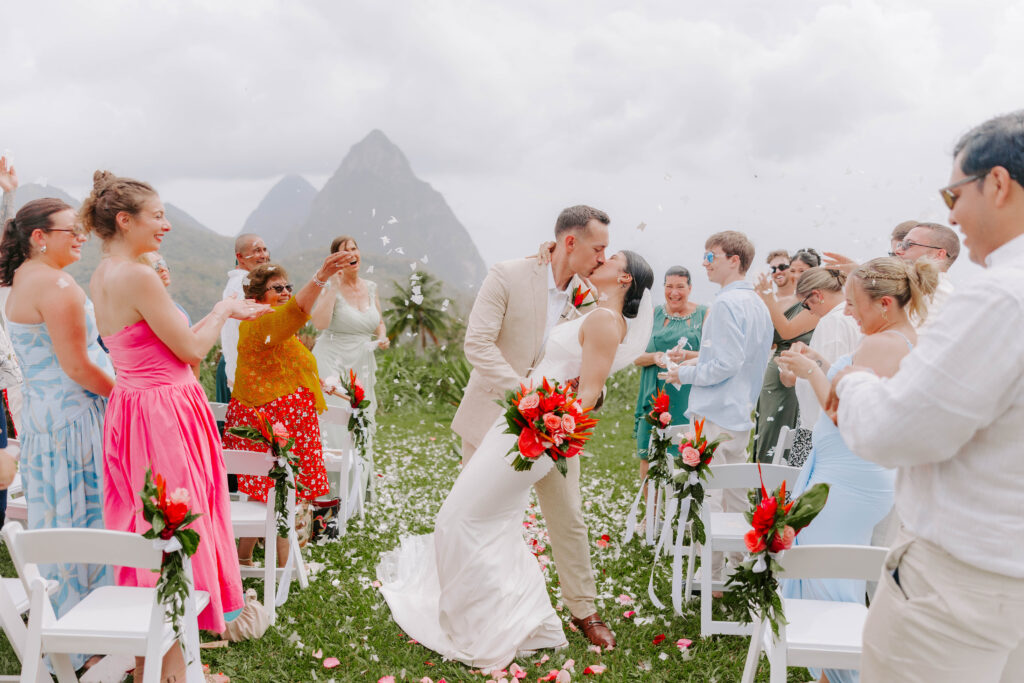 Bride and groom dipping and kiss with the Pitons in the background at La Haut Resort in St. Lucia.