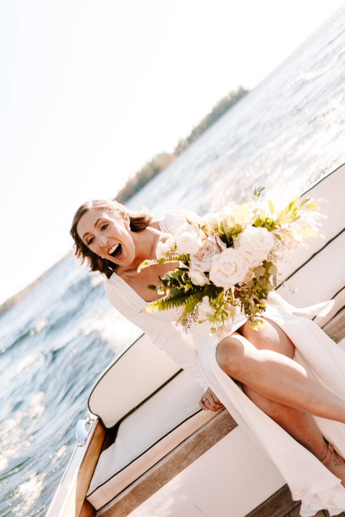 Bride gets on boat to head to ceremony on Sebago lake in Maine