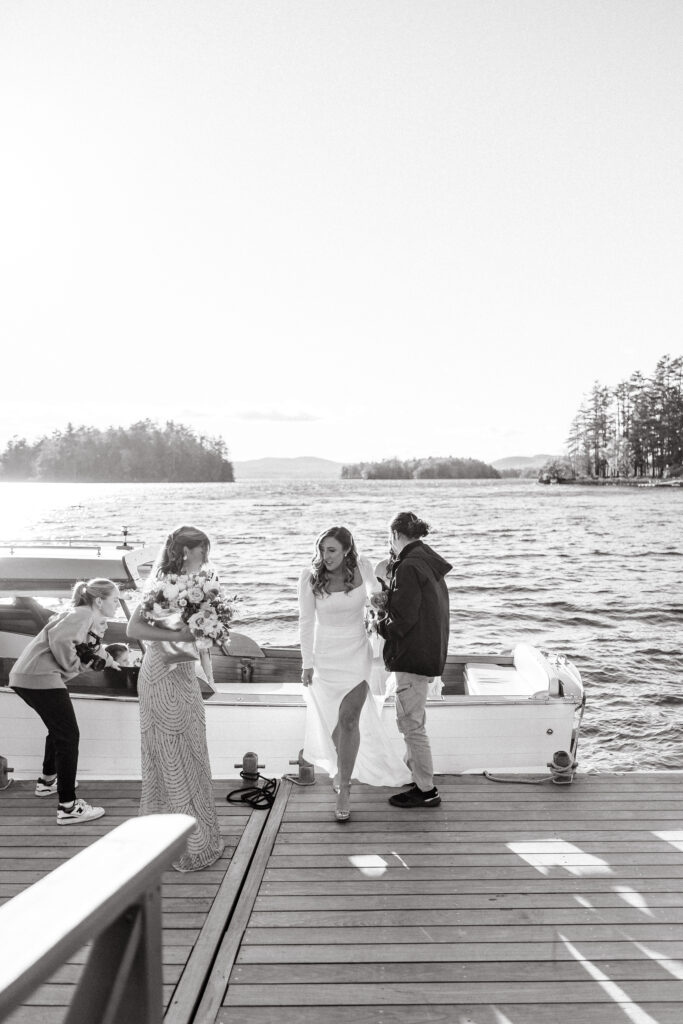Bride gets on boat to head to ceremony on Sebago lake in Maine