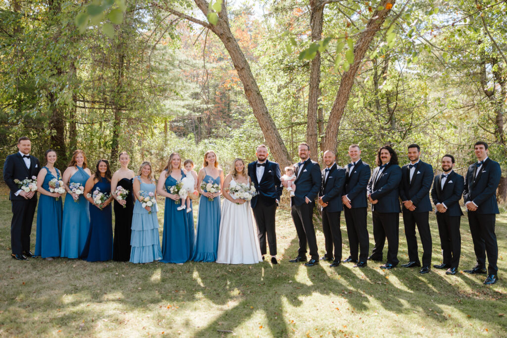 Full wedding party photo under the trees at The Point on Great Diamond Island