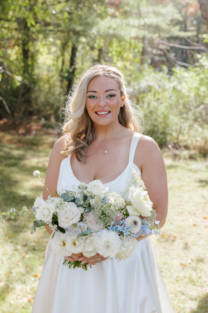 • Bride surrounded by her bridesmaids holding lush floral bouquets in Maine