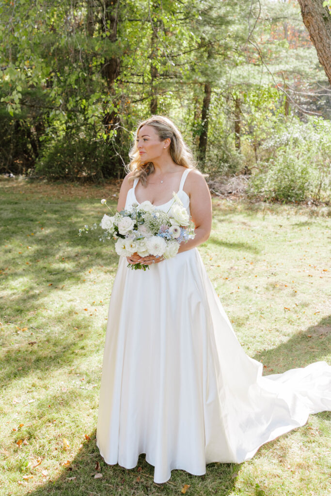 • Bride surrounded by her bridesmaids holding lush floral bouquets in Maine