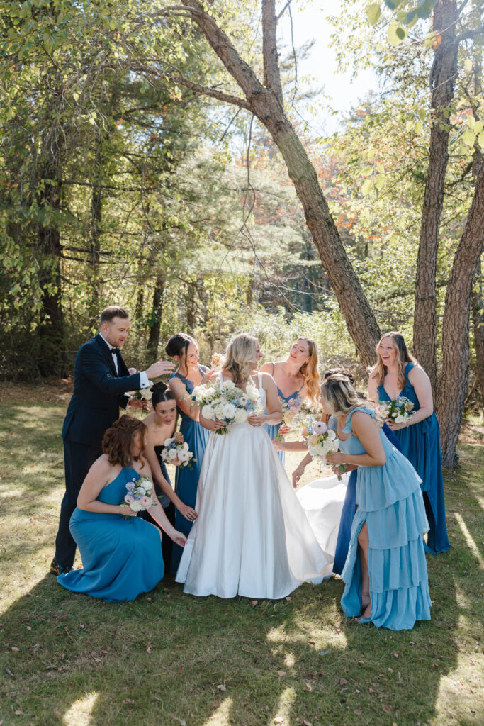 Bridesmaids helping the bride with her dress before the Great Diamond Island wedding ceremony