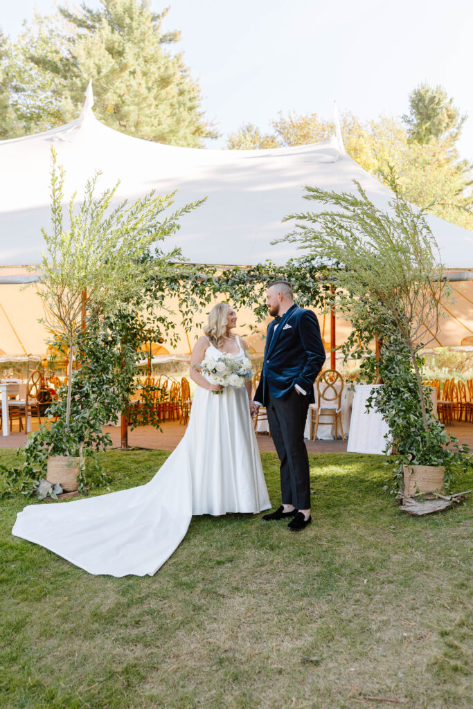 Bride and groom portraits under the reception tent surrounded by candles and elegant floral décor on Great Diamond Island