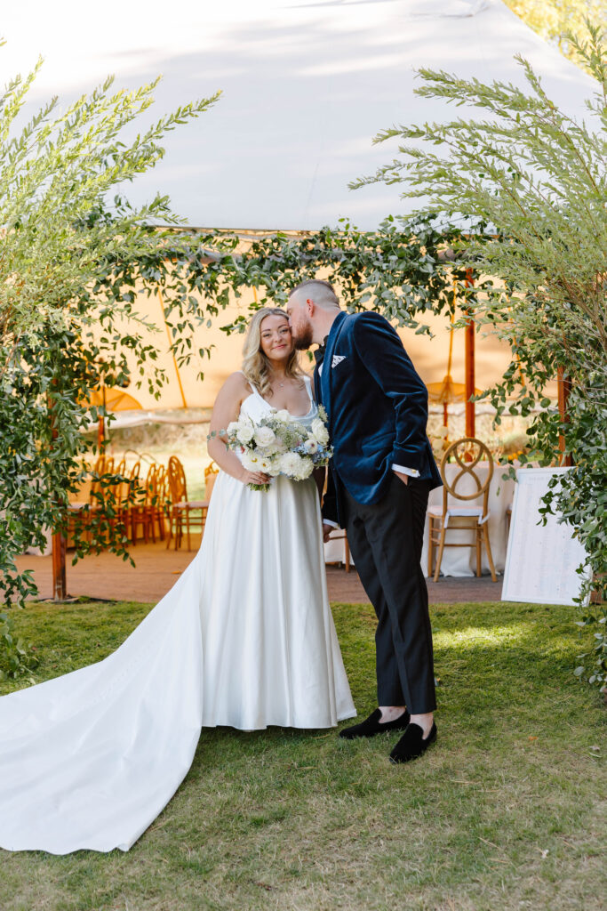 Bride and groom portraits under the reception tent surrounded by candles and elegant floral décor on Great Diamond Island