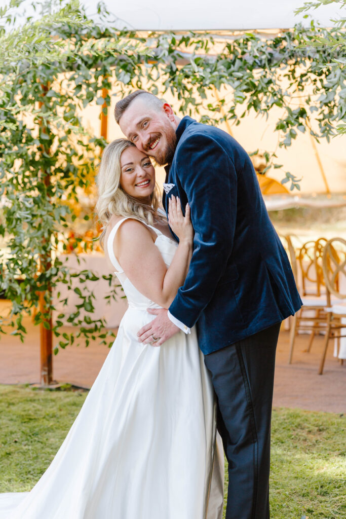 Bride and groom portraits under the reception tent surrounded by candles and elegant floral décor on Great Diamond Island