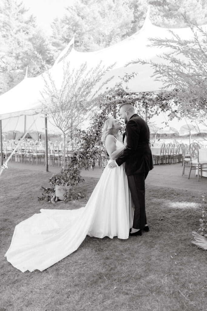 Bride and groom portraits under the reception tent surrounded by candles and elegant floral décor on Great Diamond Island