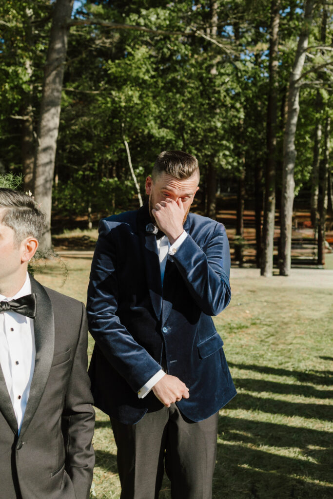 Groom reaction to bride walking down isle at wedding ceremony