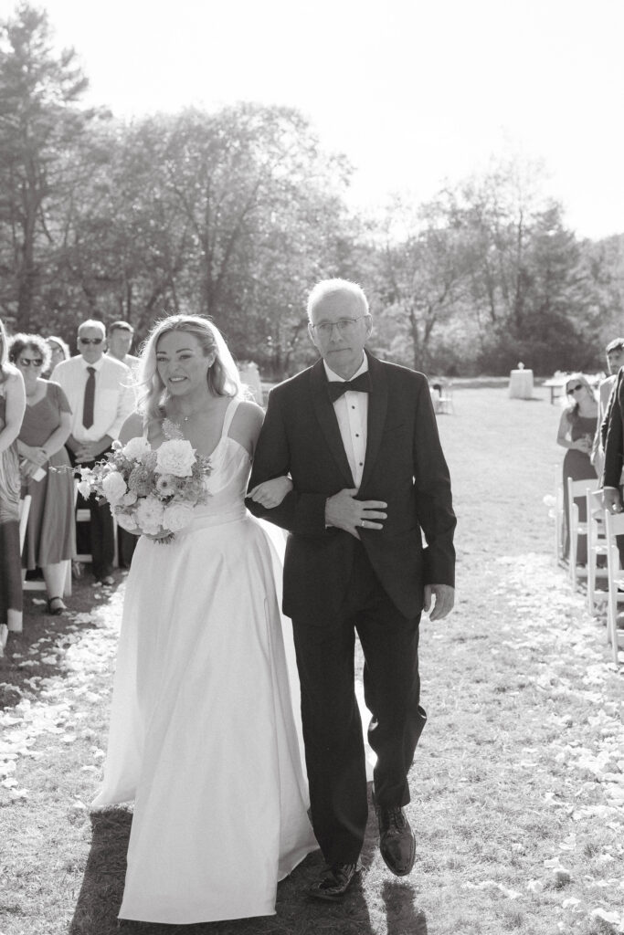 Bride walking down the aisle during the Great Diamond Island wedding ceremony overlooking the oceanceremony