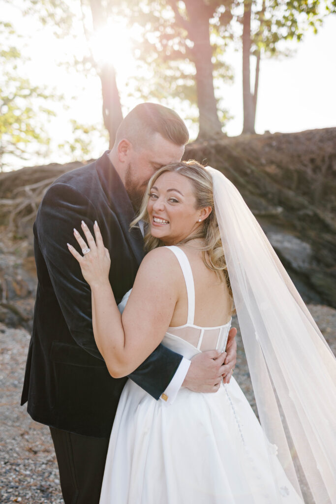 Bride and groom walking hand in hand along the shoreline during their coastal Maine wedding