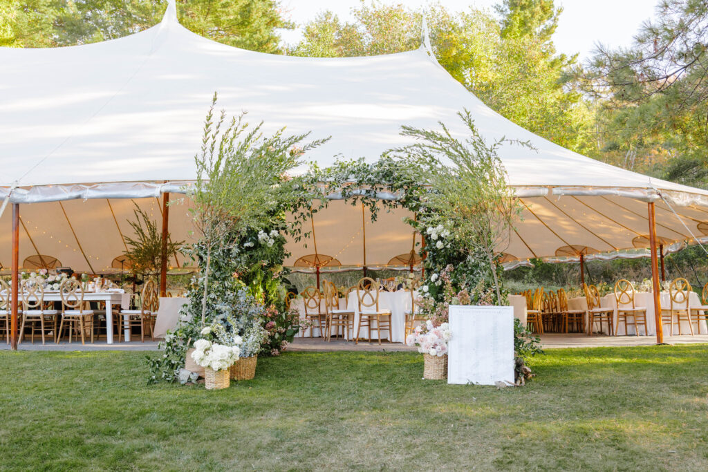 Elegant floral arbor welcoming guests into the tented Great Diamond Island wedding reception