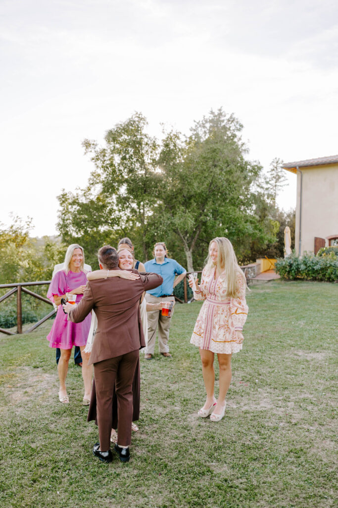 Groom hugs guests for welcome party