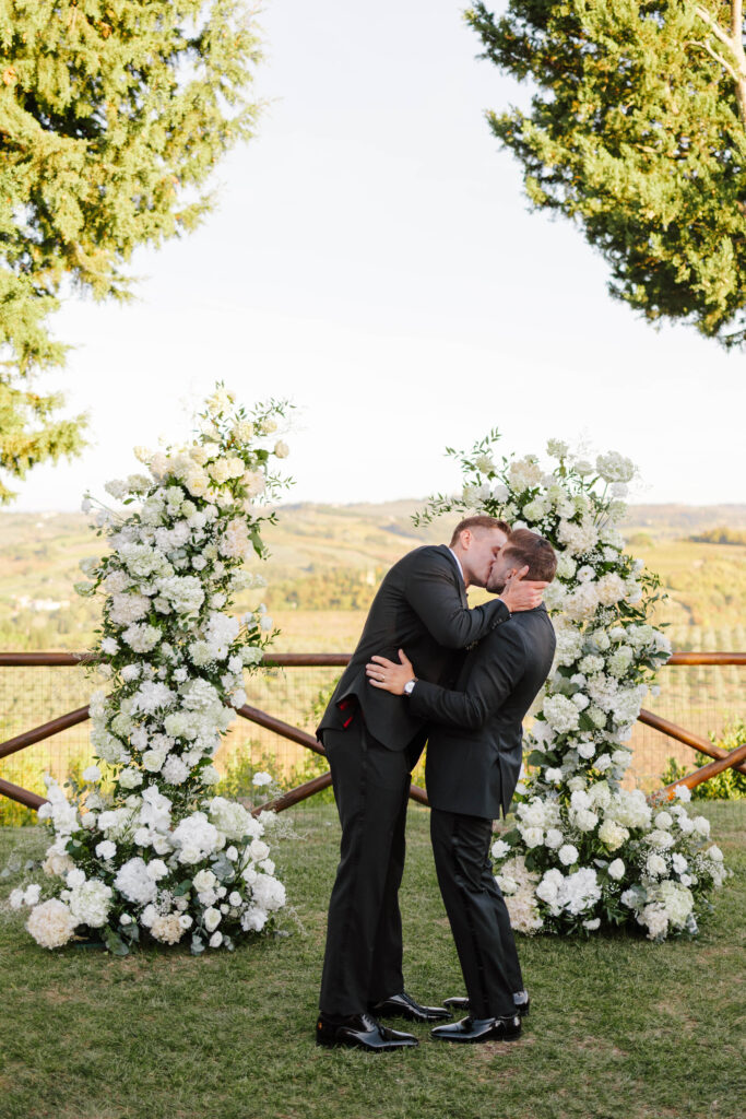 Grooms kiss at wedding ceremony in Tuscany Italy