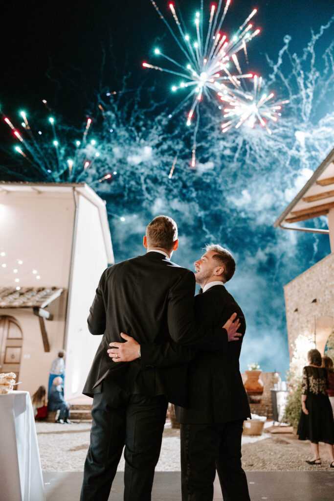 Grooms share moment under fireworks lighting up the Tuscany sky
