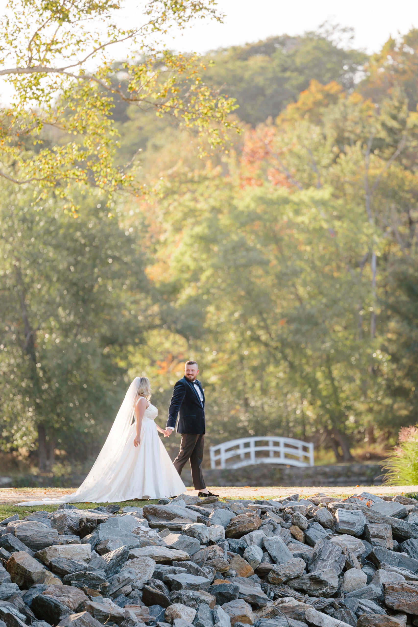 groom walks with bride on wedding at Great Diamond Island, Maine
