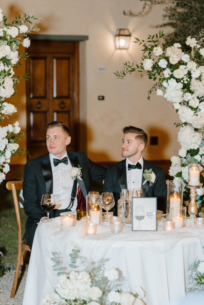 grooms listen to toasts being given during their wedding reception