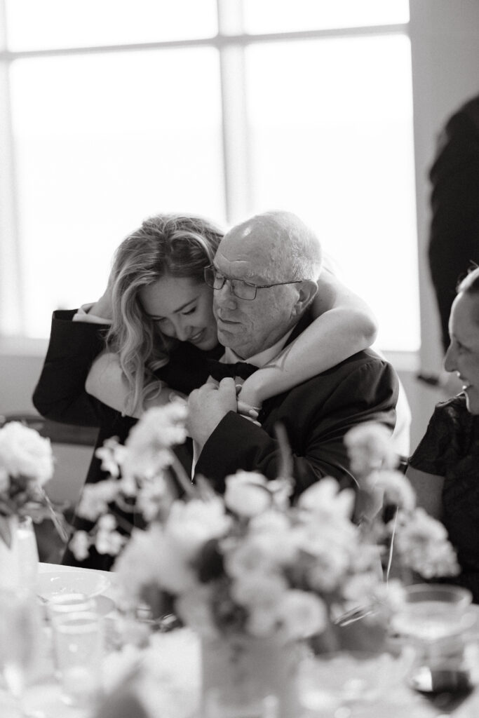 Bride gives dad hug after wedding toast.