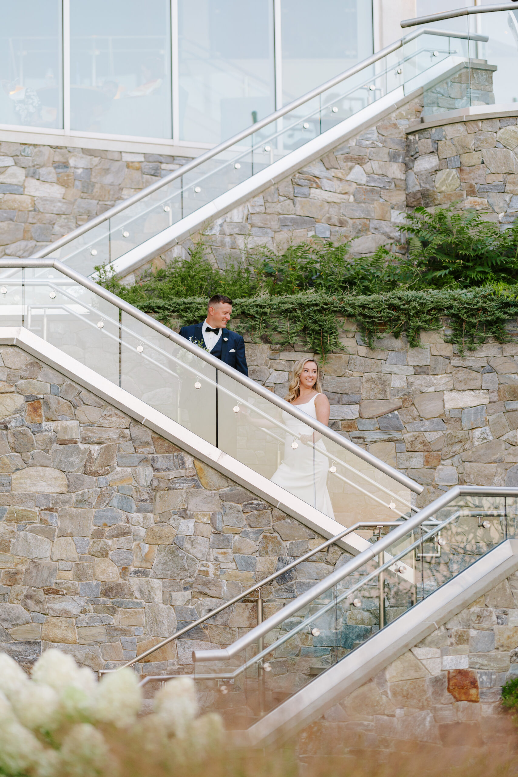 bride and groom walking up stairs at the cliff house maine wedding