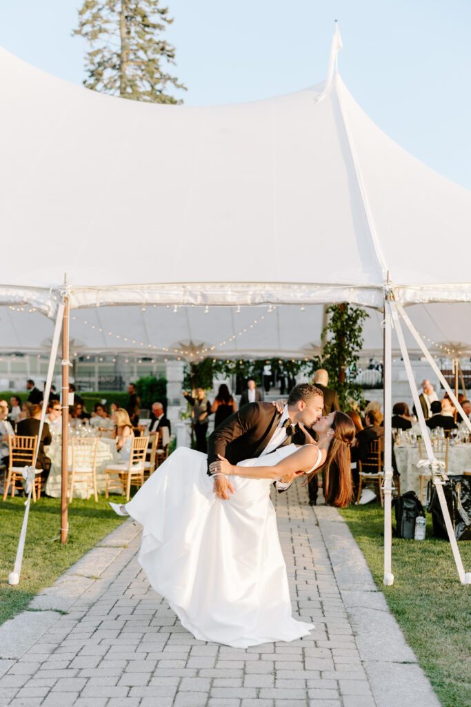 groom dips bride at tented reception by eastcoast wedding photographer