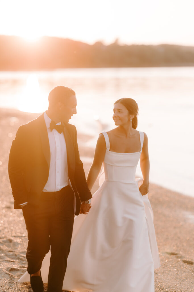 bride and groom walk at sunset on the beach at the bar harbor club