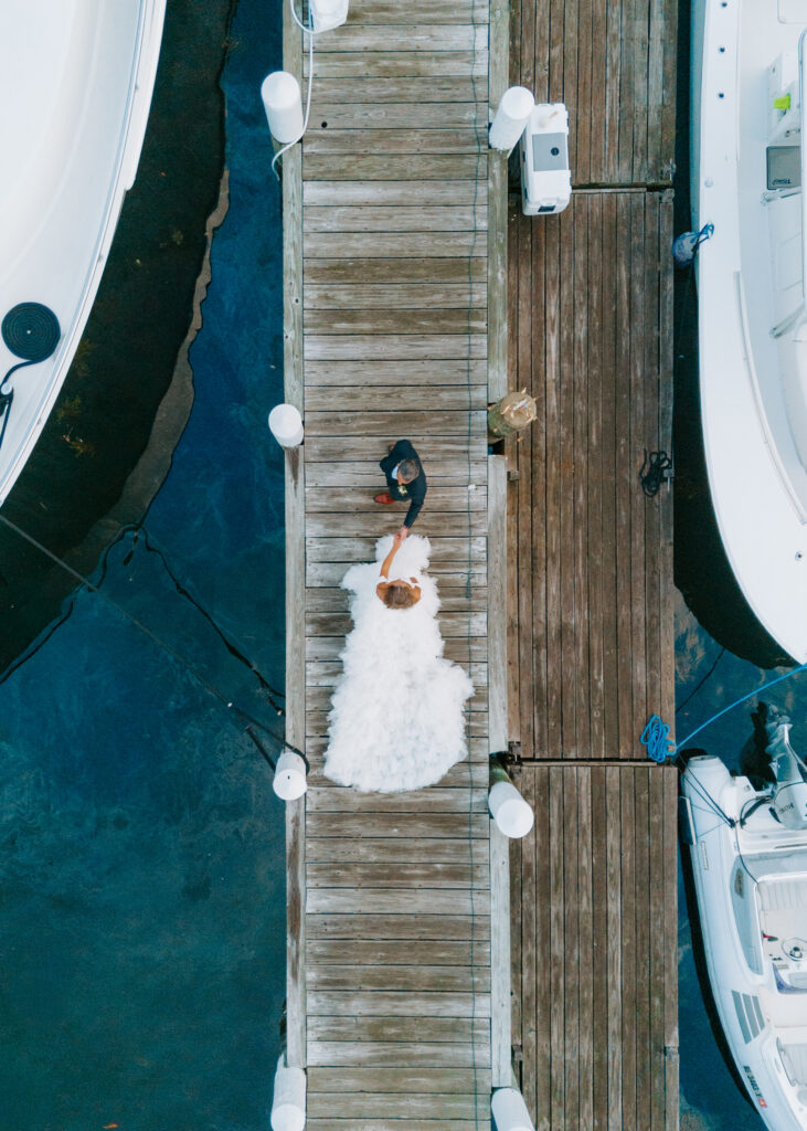 bride and groom walking down dock at wedding day