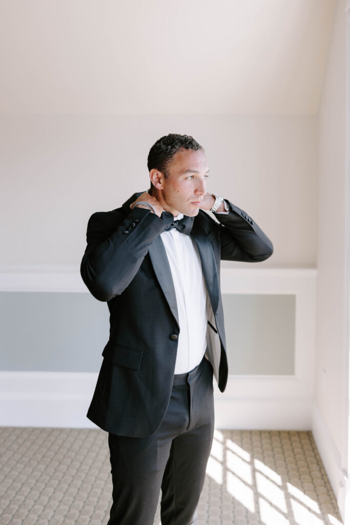 groom adjusts tie on wedding day taken by boston wedding photographer