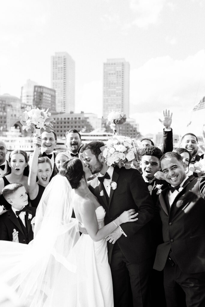 wedding party cheers for bride and groom in boston water front