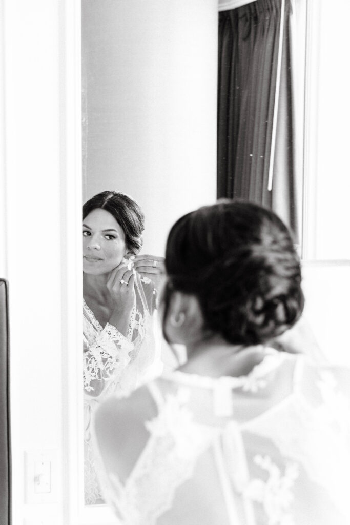 bride puts ear rings on in hotel room in boston