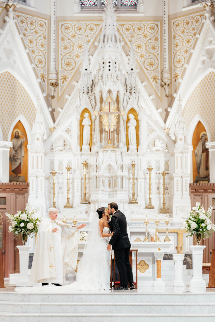 bride and groom share first kiss at wedding ceremony at