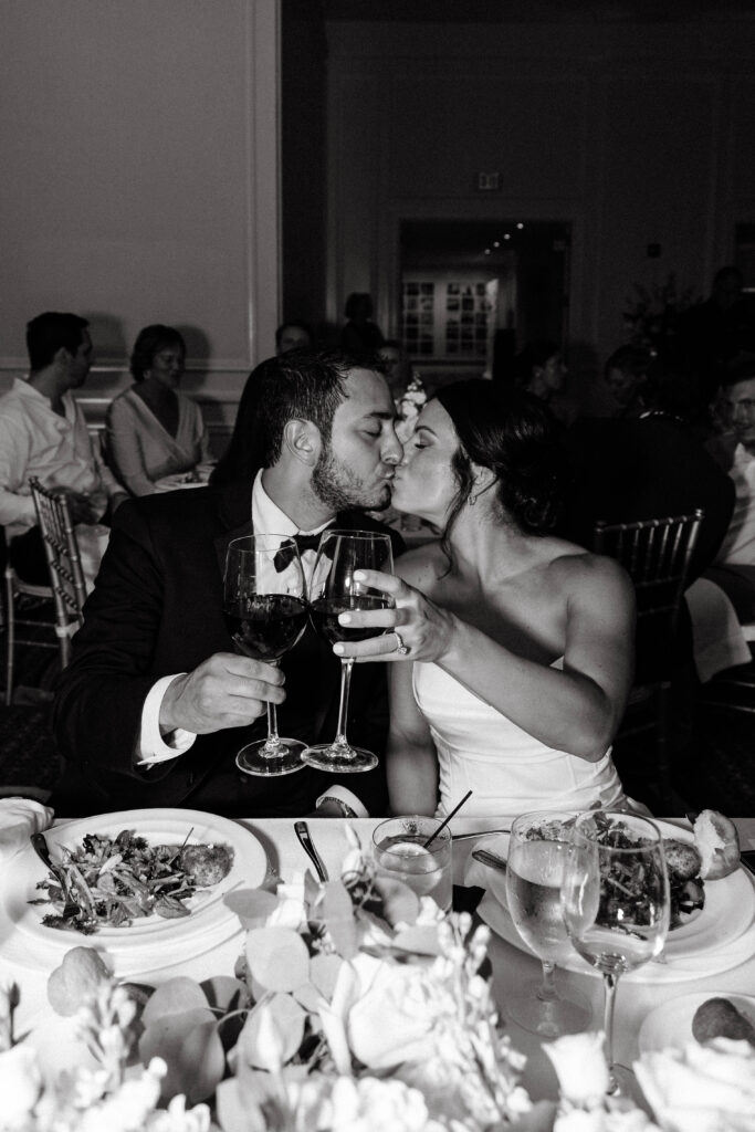 bride and groom share kiss during wedding reception
