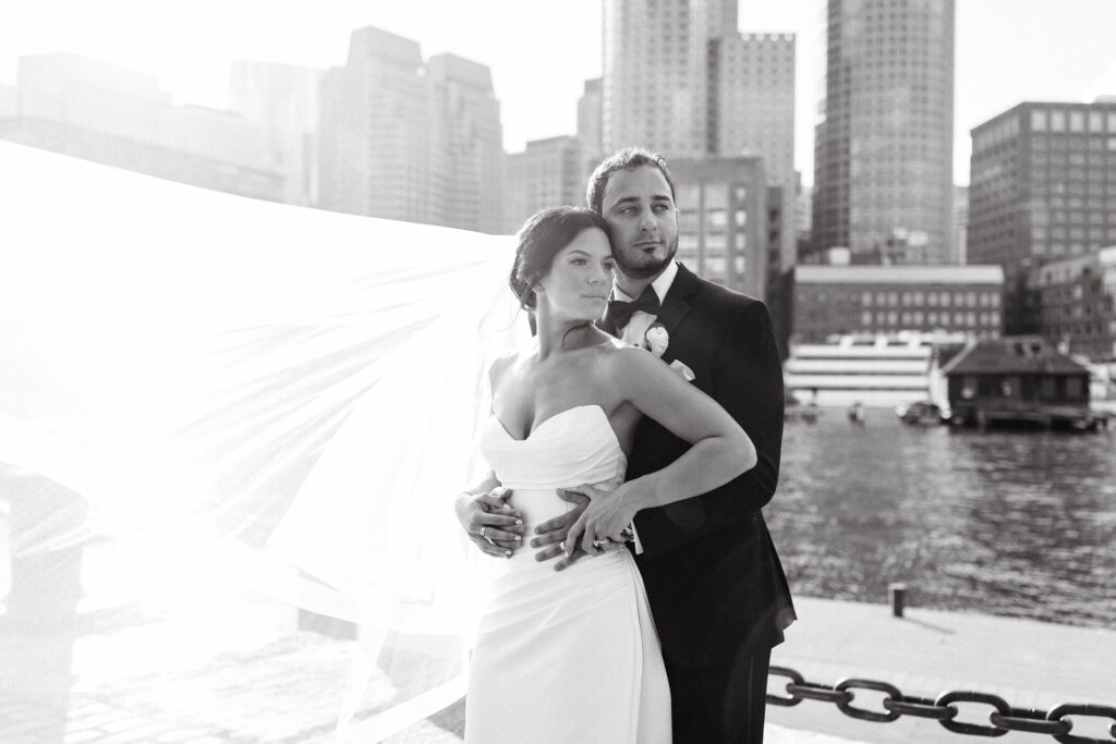 bride and groom smile att boston skyline