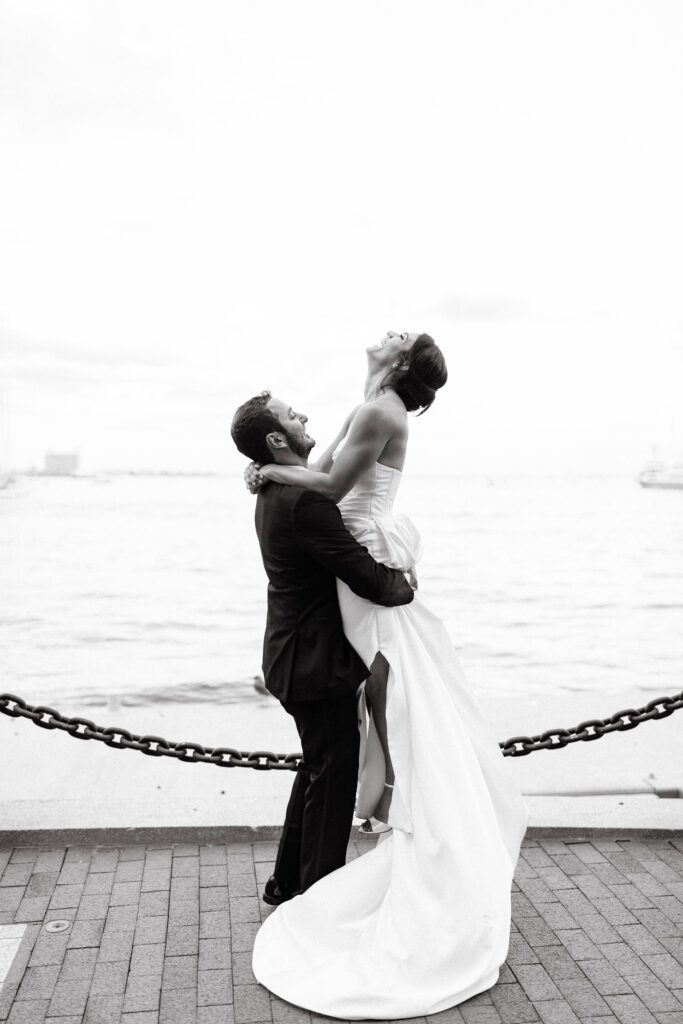 groom lifts bride at boston harbor hotel