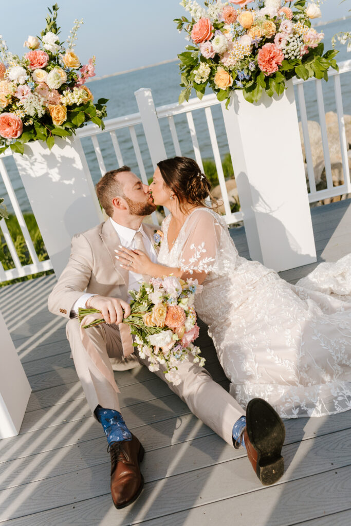 bride and groom share kiss with beautiful floral arrangements