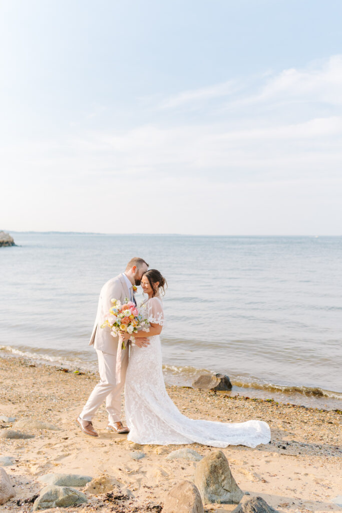 bride and groom walking on beach in massachusetts