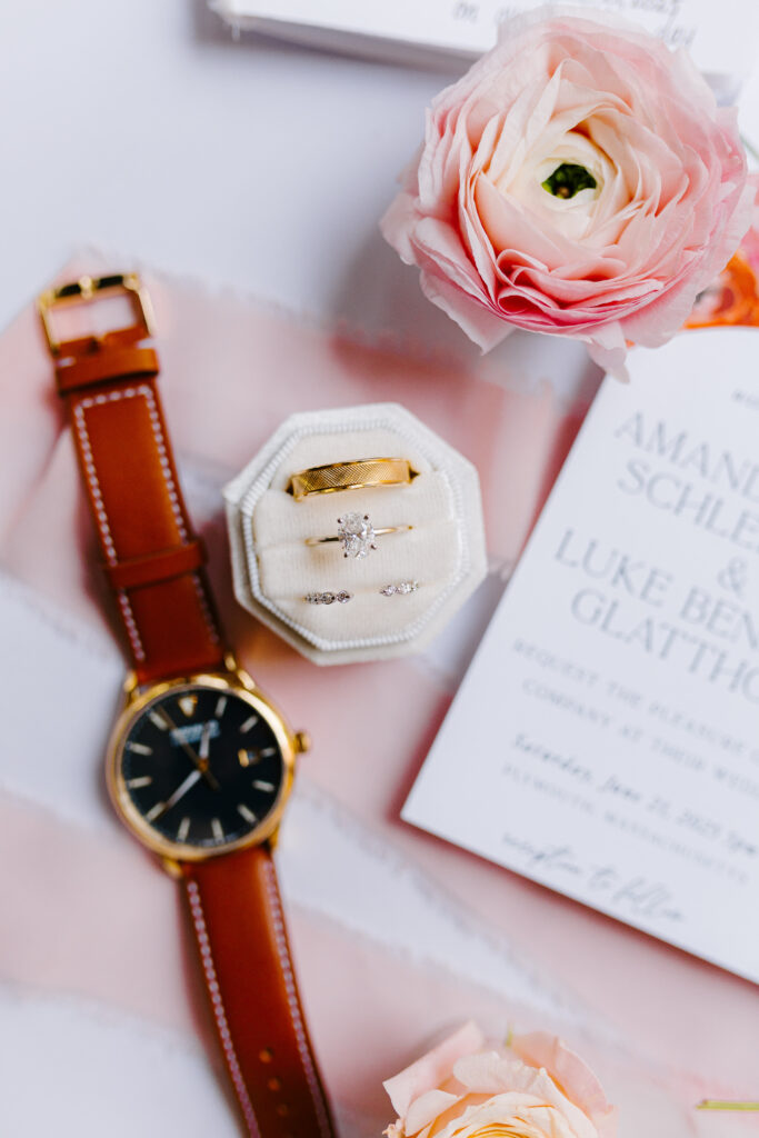 detail shot of wedding rings and watch with floral