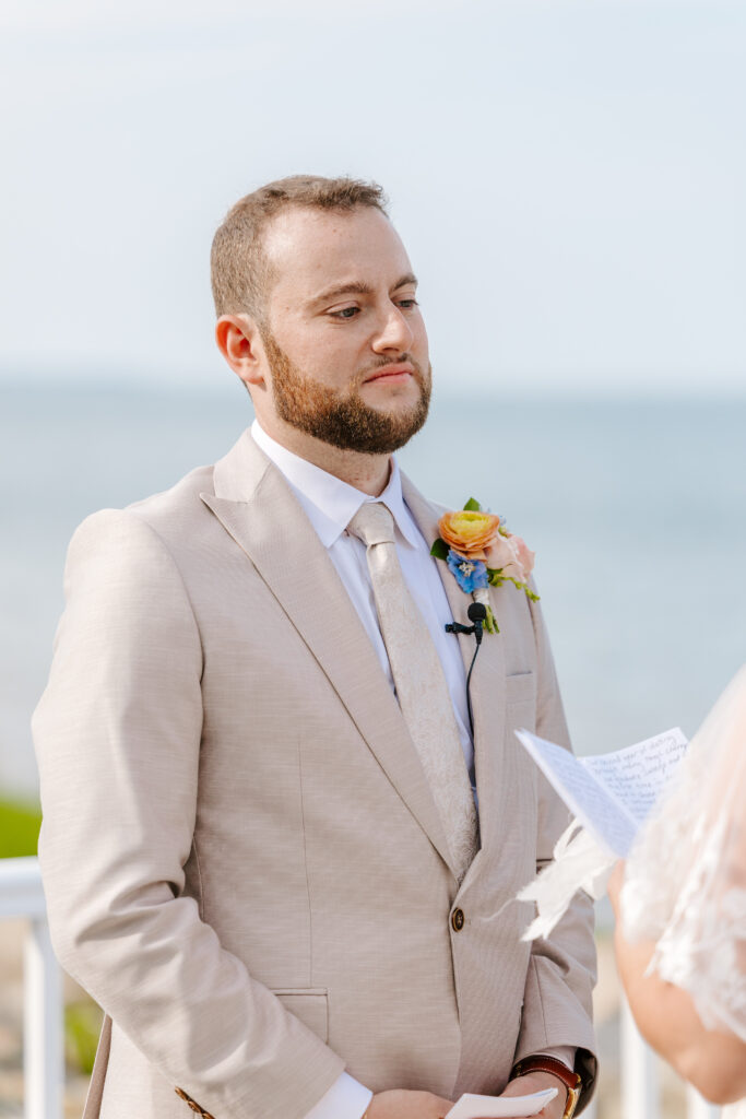 close up of groom at wedding ceremony on plymouth harbor
