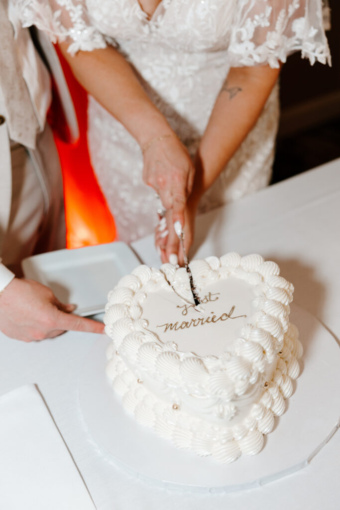 detail photo of bride and groom cutting wedding cake
