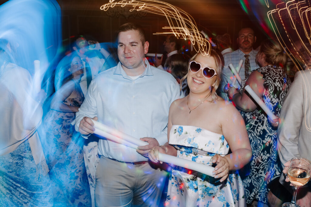 two wedding guests smile on reception dance floor