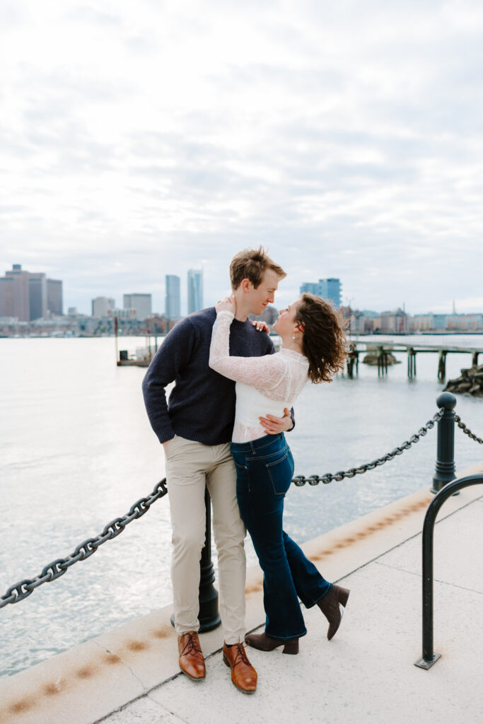 Couple looking at each other through Boston park during engagement session