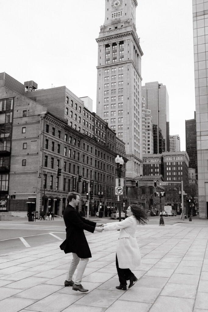 Boston engagement photos at Custom House Tower with couple dancing in the street