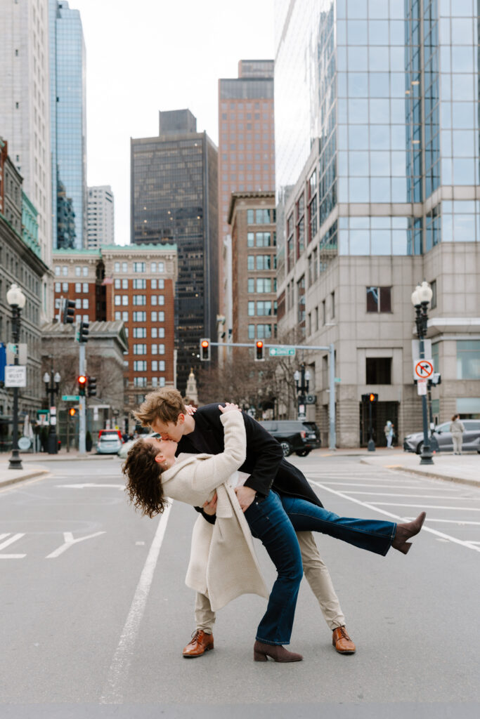 Playful Boston engagement session dip kiss in downtown Boston street