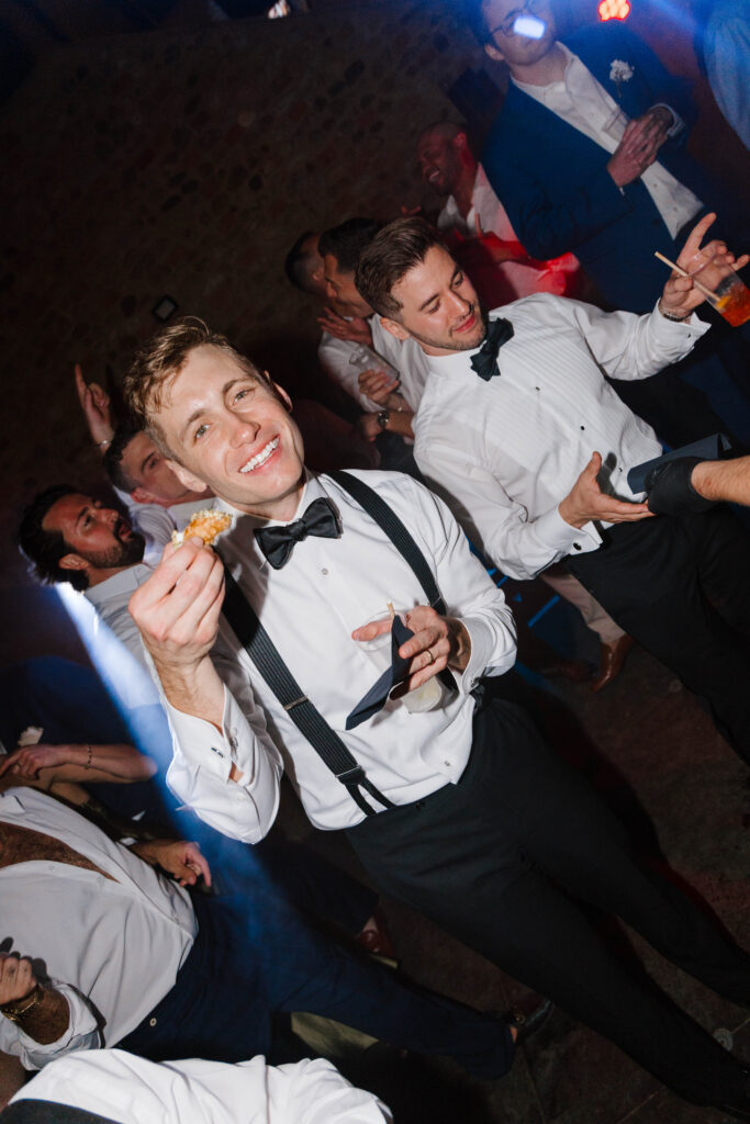 groom holds cannoli at wedding reception