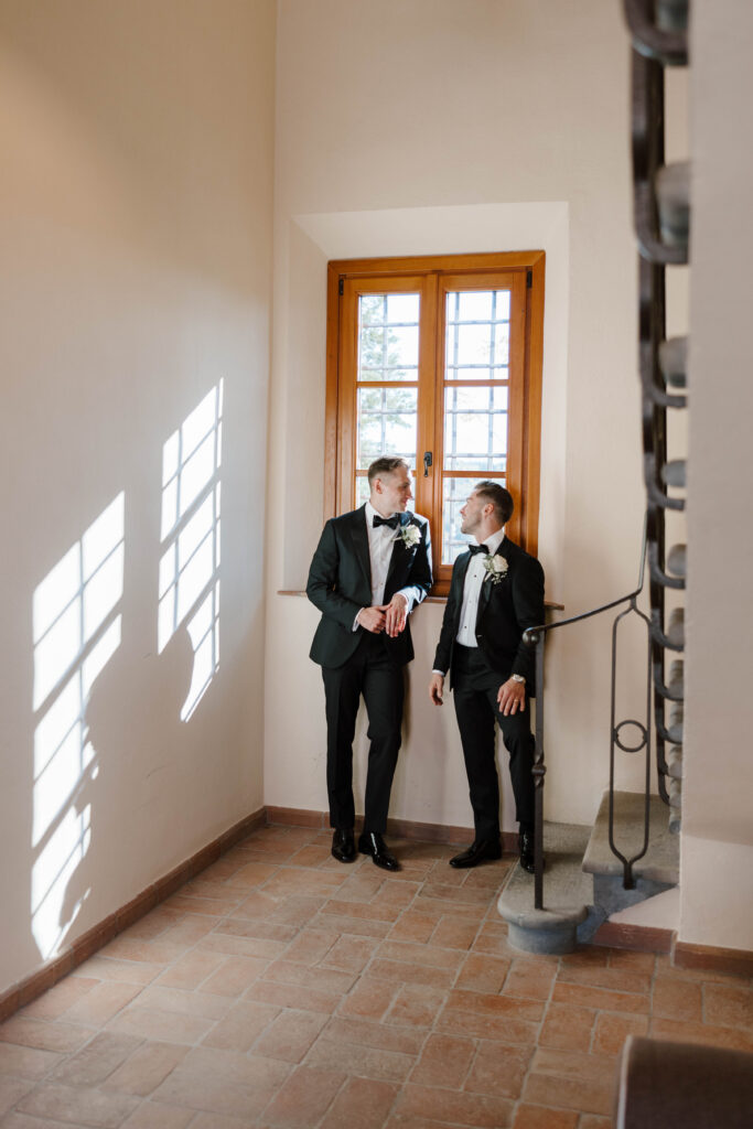 grooms smile at each other on wedding day taken by destination wedding photographer