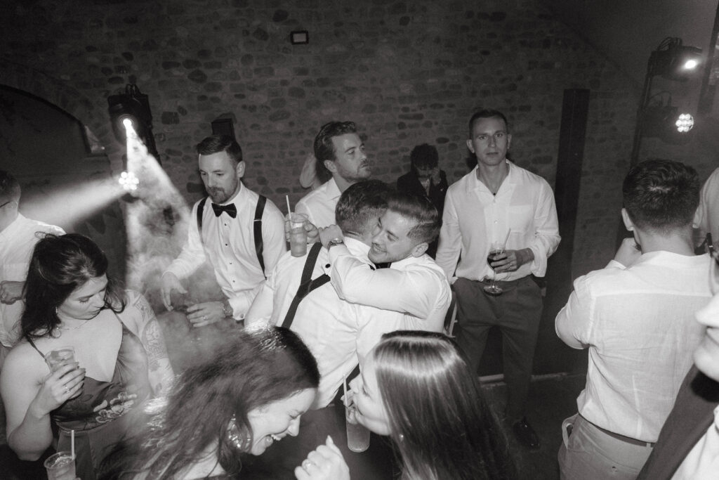 grooms hug at reception taken by tuscany wedding photographer