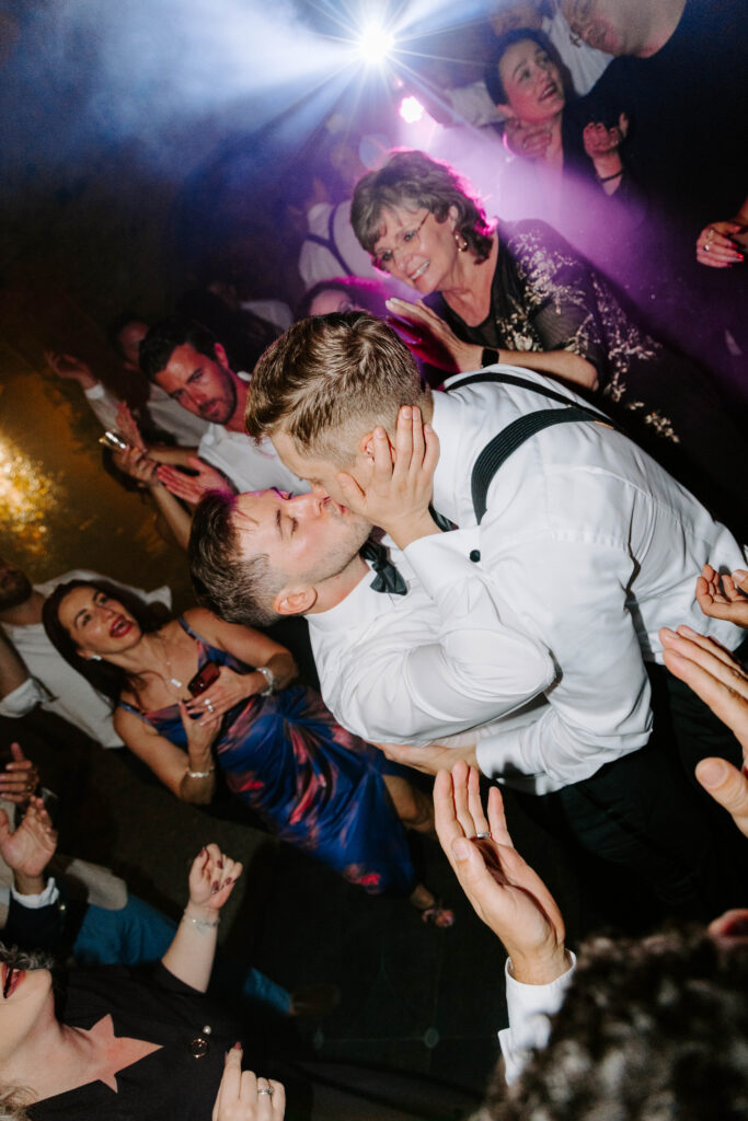 grooms kiss at wedding reception taken by europe wedding photographer