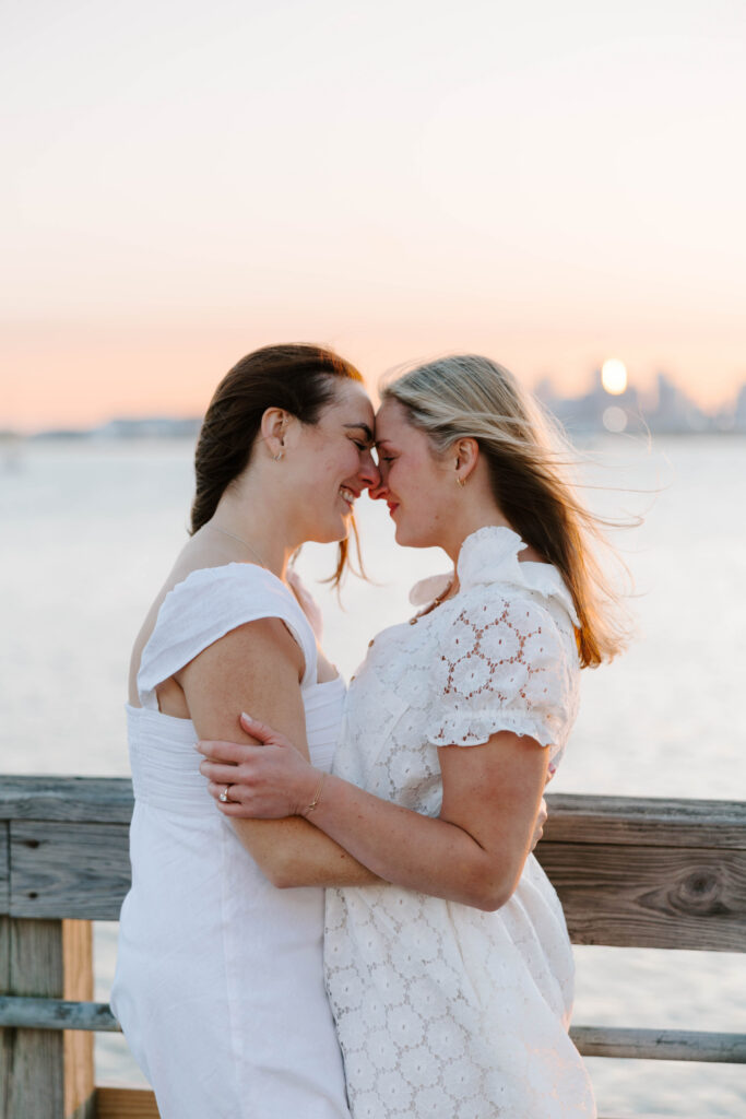 Couple touching foreheads with sun flare during Boston waterfront session