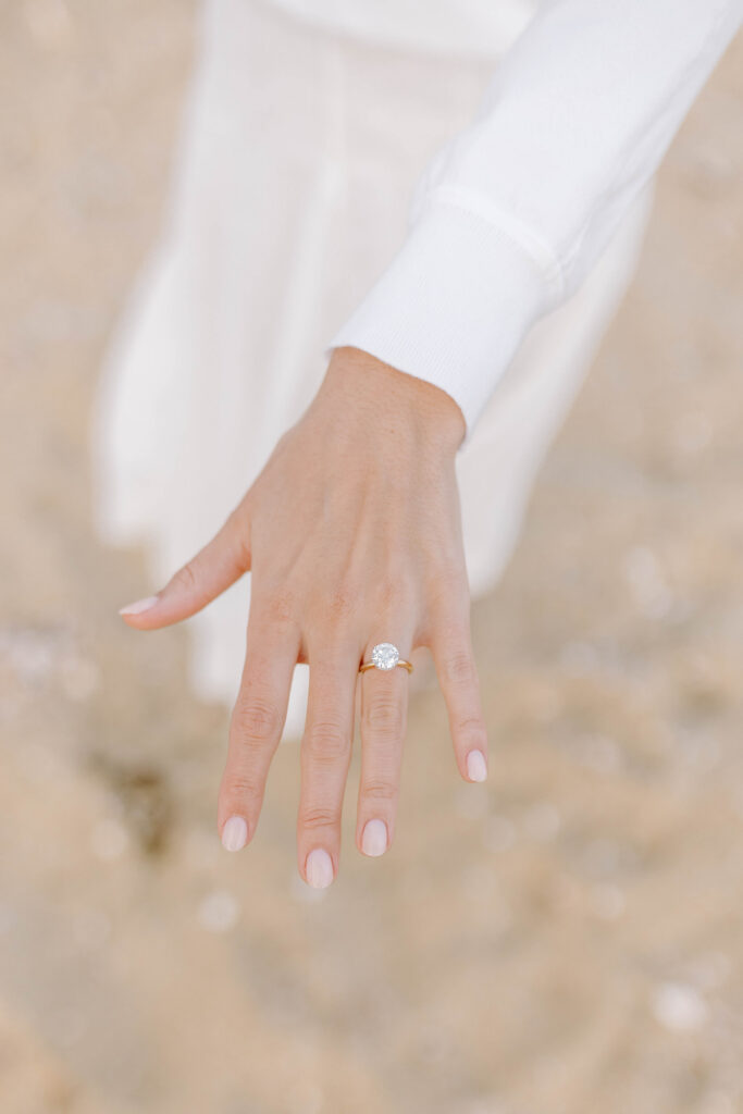 detail photo of woman's hand with engagement ring