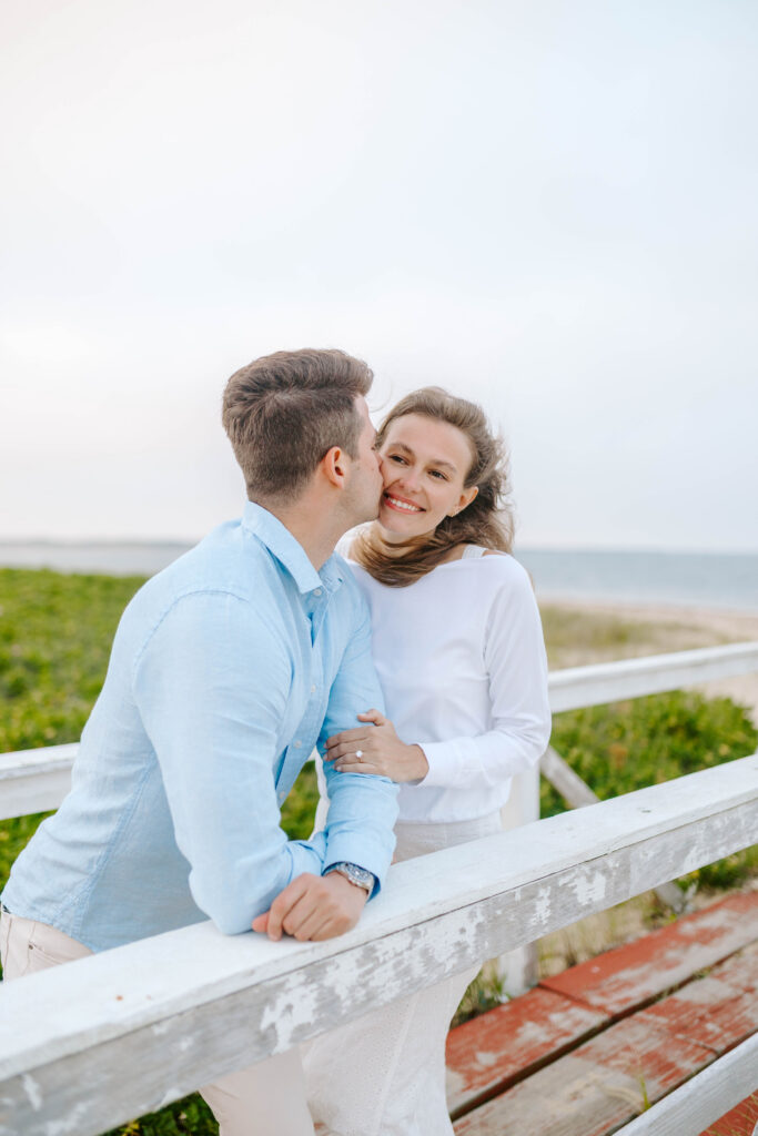 woman smiles as man kisses her cheek
