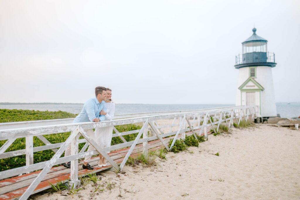 couple looks off into distance on the beach in cape cod