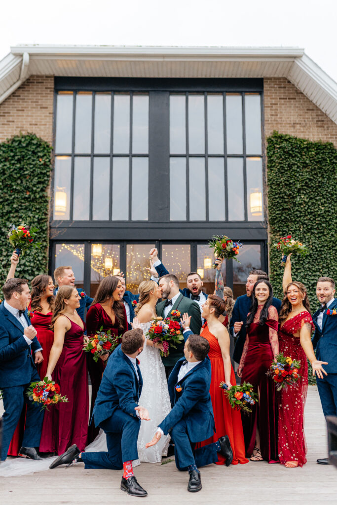 wedding party cheers with bride and groom at venue taken by rhode island photographer